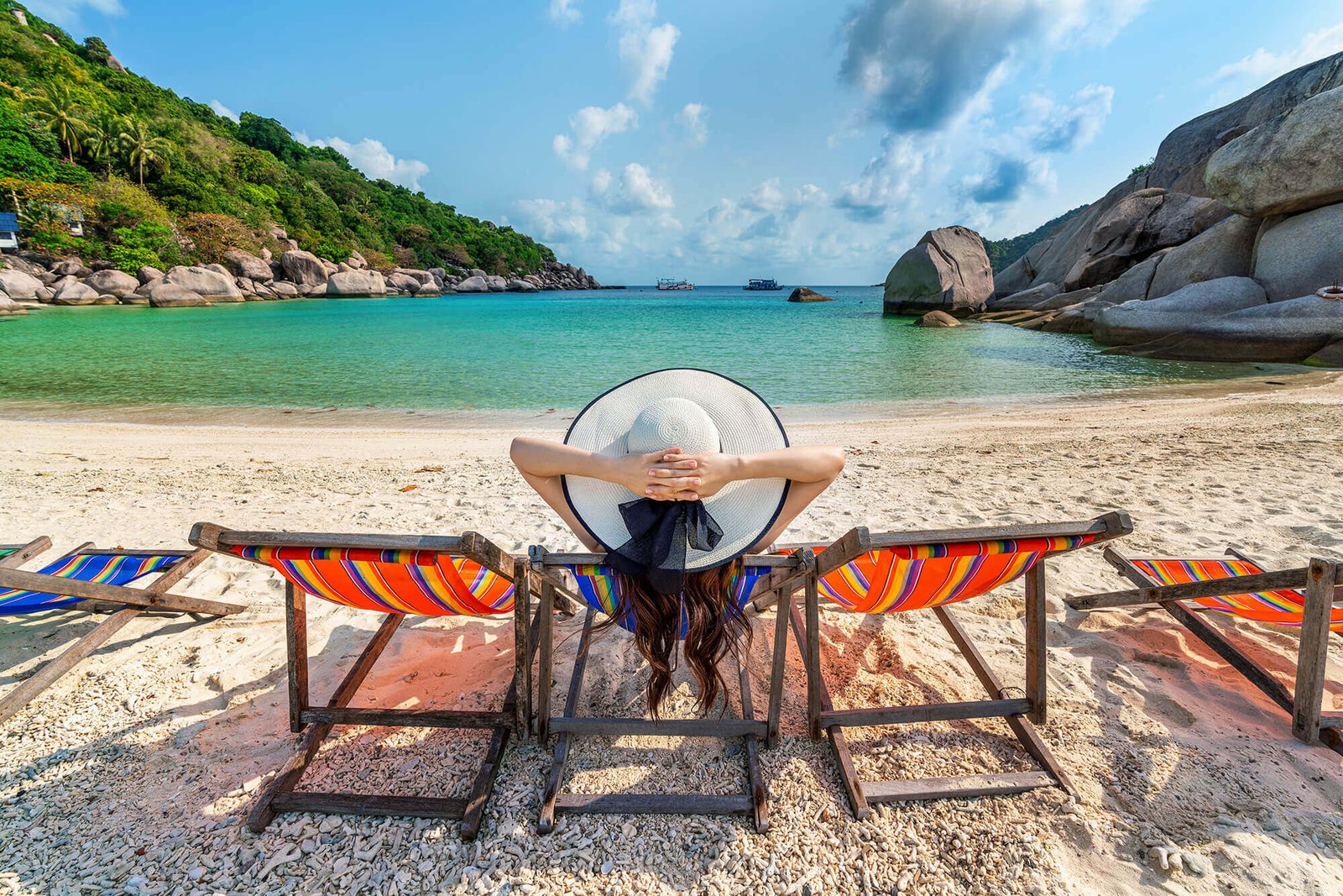 woman with hat sitting chairs beach beautiful