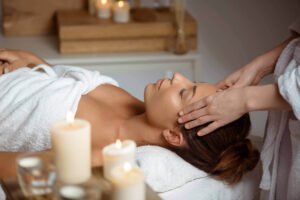 young woman having face massage relaxing spa salon